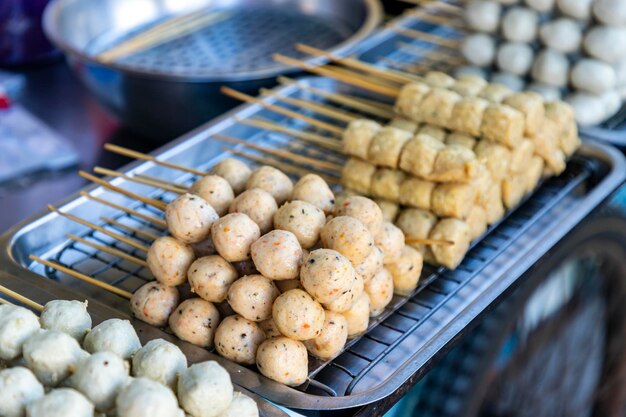 Le polpette in stile thailandese su spiedini verranno in un carrello per essere vendute sul lato pubblico della strada c'è una padella e olio caldo per la frittura le salse di immersione sono sia dolci che piccanti attenzione selettiva