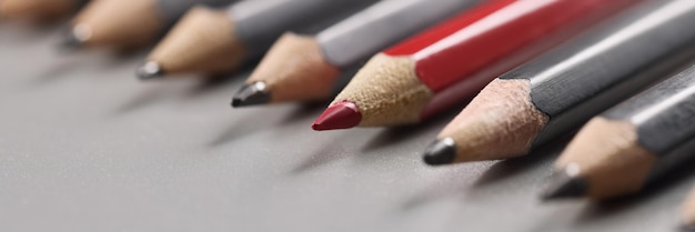 Le punte delle matite mettono su una superficie grigia in ordine rigoroso quella rossa tra le penne nere