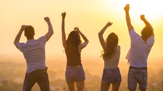 Le quattro persone che ballano sullo sfondo dell'alba