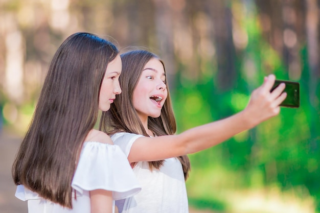 Le ragazze adolescenti si fanno selfie nella foresta estiva