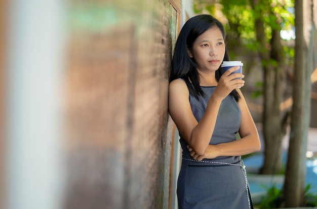 Le ragazze asiatiche bevono il caffè caldo in caffetteria