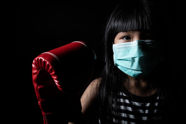 Le ragazze asiatiche indossano maschere per proteggersi dai virus e indossano guantoni da boxe per simboleggiare i virus da combattimento come Coronavirus