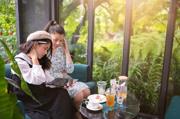 Le ragazze bevono il caffè si rilassano al bar Il freelance comunica sul progetto le ragazze fanno acquisti online su tablet wifiStudi degli studenti su internetProcesso aziendale di lavoro