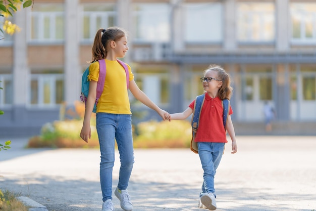 Le ragazze con lo zaino vanno a scuola