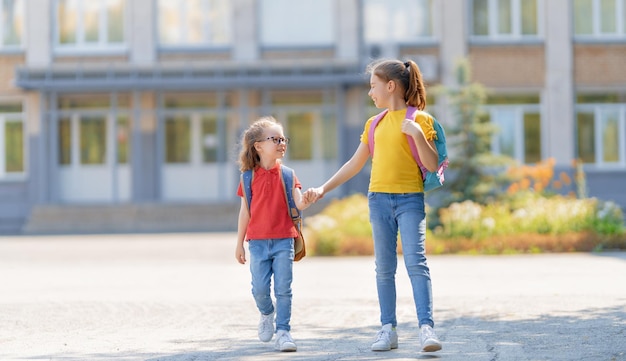 Le ragazze con lo zaino vanno a scuola