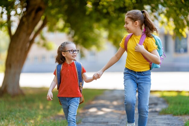 Le ragazze con lo zaino vanno a scuola