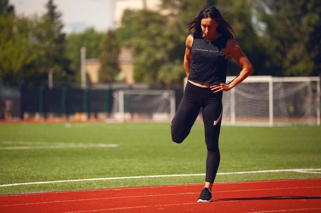 Le ragazze di atletica leggera nello stadio fanno esercizi