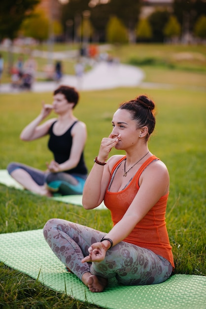 Le ragazze fanno yoga all'aperto nel parco durante il tramonto. Uno stile di vita sano.