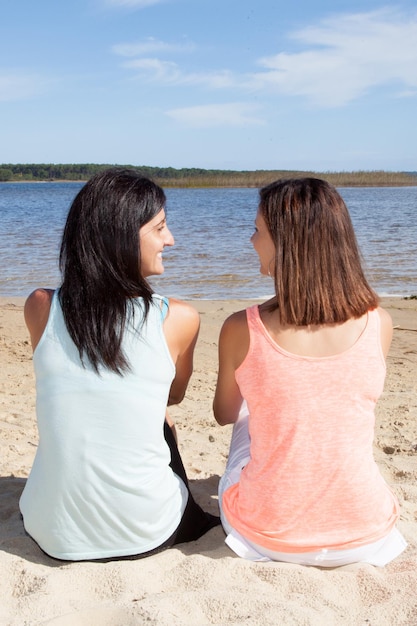 Le ragazze felici accoppiano due femmine nelle vacanze estive