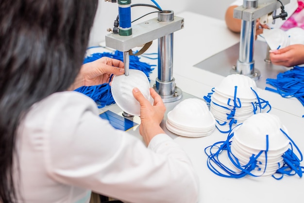 Le ragazze lavorano alla macchina per la fabbricazione di maschere mediche con nanofibre e le saldano con gli ultrasuoni