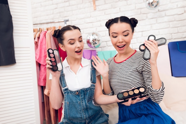 Le ragazze reggono gli ombretti colorati alla telecamera