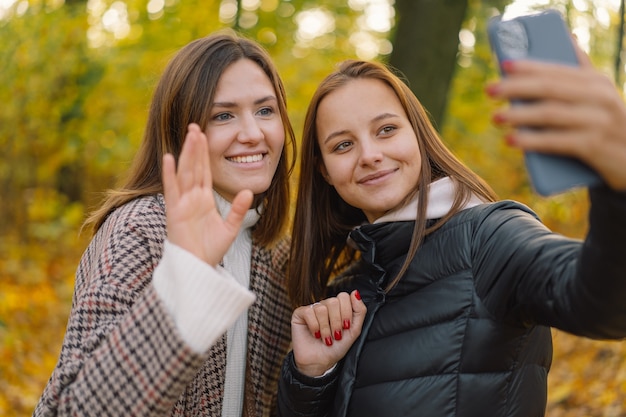 Le ragazze ridono e parlano in videochiamata al telefono del concetto di mobilità dello stile di vita