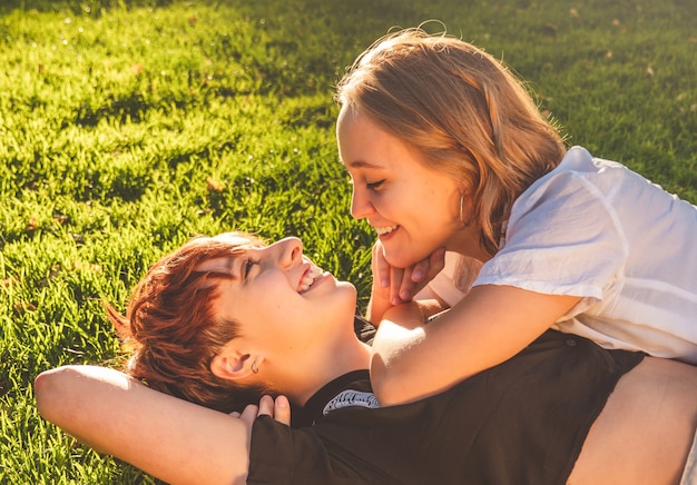 Le ragazze si accoppiano nell'amore sdraiato sull'erba in un parco in una giornata di sole