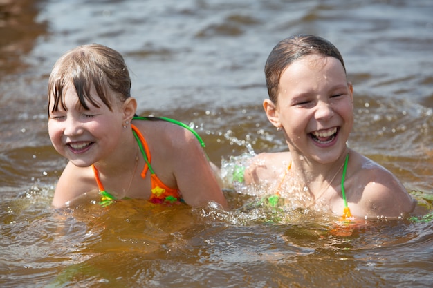 le ragazze si divertono giocando, nuotando nel fiume di ottimo umore