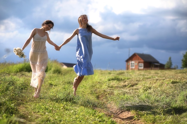 Le ragazze stanno camminando nel campo prima della pioggia