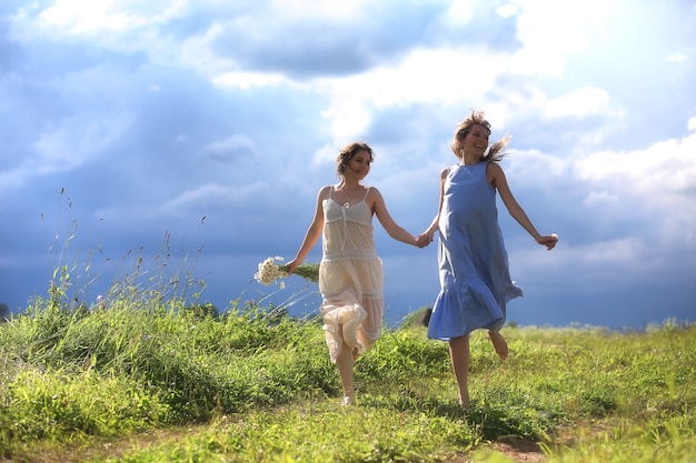 Le ragazze stanno camminando nel campo prima della pioggia