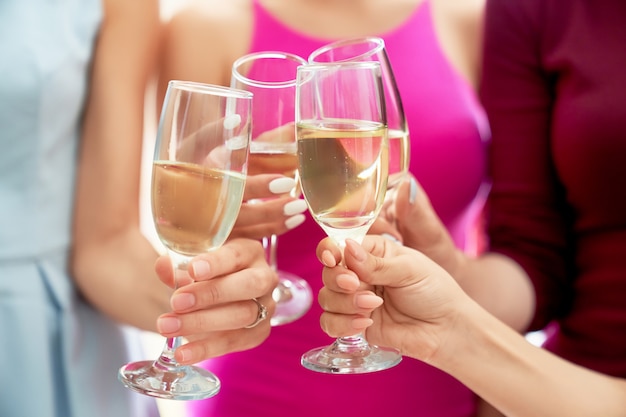 Le ragazze tintinnano di bicchieri di champagne.