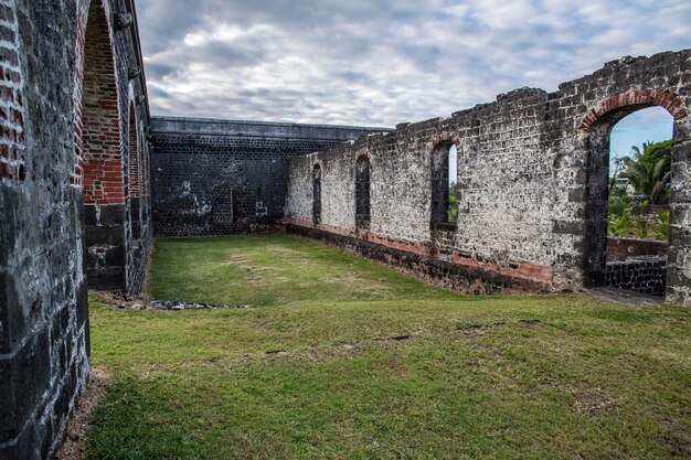 le rovine di un antico castello con mura in mattoni ed erba verde