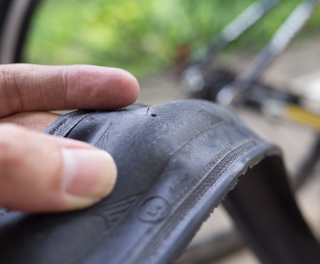 Le ruote della bicicletta sono piatte perché il rottame appuntito o il vetro rotto pungono la gomma sulla strada