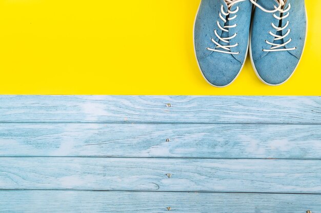 Le scarpe blu stanno su uno sfondo misto blu e giallo isolato.