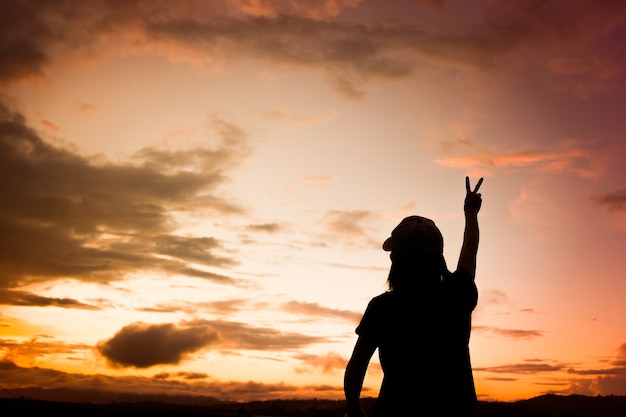 Le siluette donne asiatiche sopra il bello tramonto hanno messo il fondo.