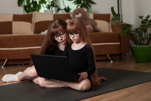 Le sorelle delle bambine tengono una lezione di ginnastica online a casa