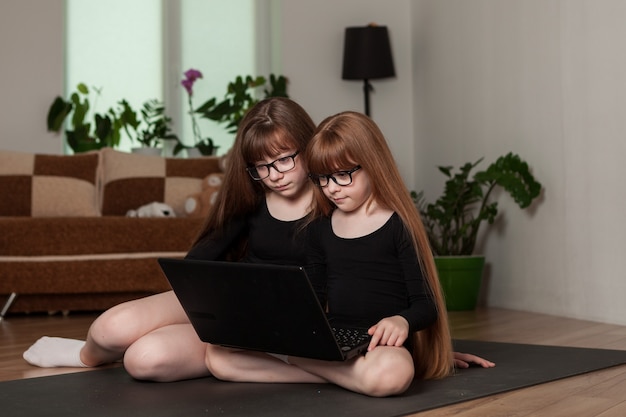 Le sorelline delle bambine tengono una lezione di ginnastica online a casa