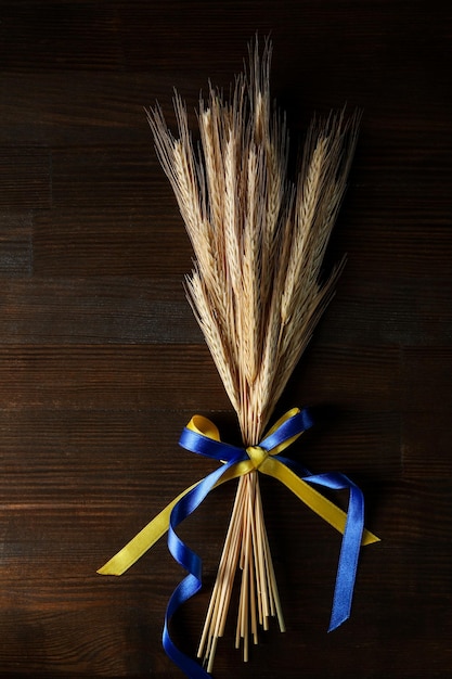 Le spighette con la bandiera ucraina colorano i nastri su fondo di legno