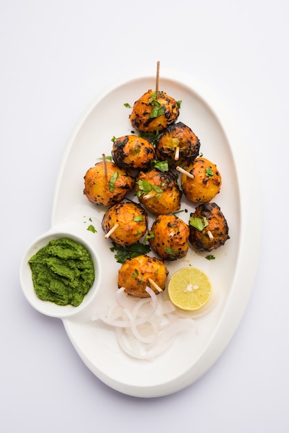 Le tandoori aloo sono patate arrosto con spezie indiane. È un antipasto da festa servito con chutney verde. messa a fuoco selettiva