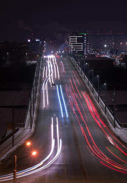 Le tracce di luce dell'auto sull'autostrada nella città moderna di notte