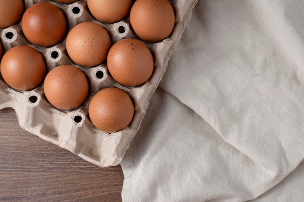 Le uova di gallina fresche nel pannello superiore sono poste sul tavolo
