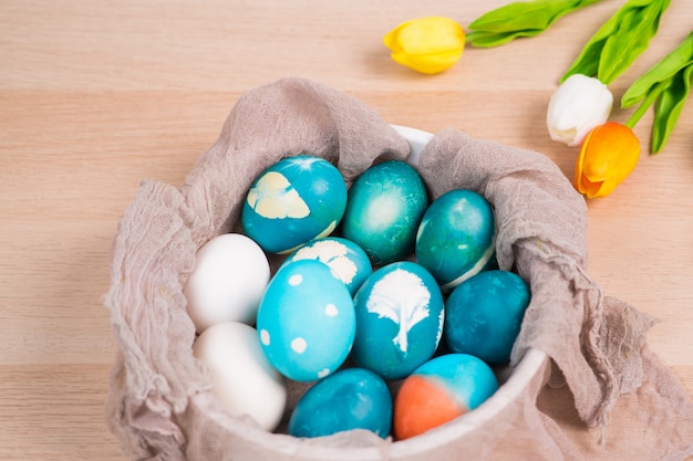 le uova di Pasqua blu organiche con le uova di colore bianco aspettano per dipingere