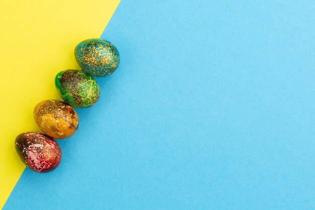 Le uova di Pasqua colorate Multi si trovano in una fila.