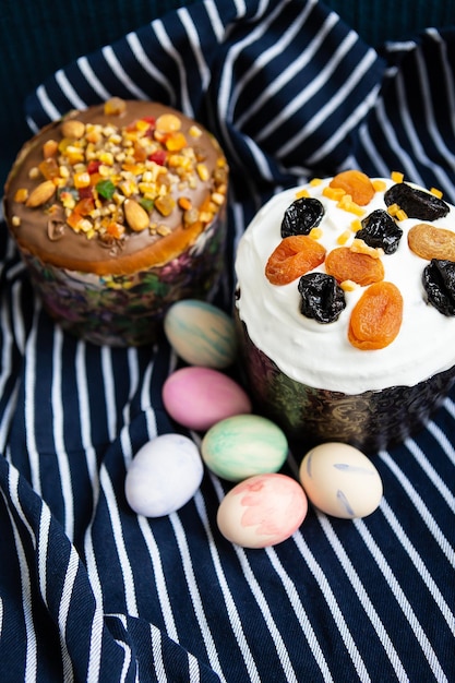 Le uova di Pasqua e le torte di Pasqua giacciono su un grembiule blu a strisce Concetto di festa religiosa di Pasqua