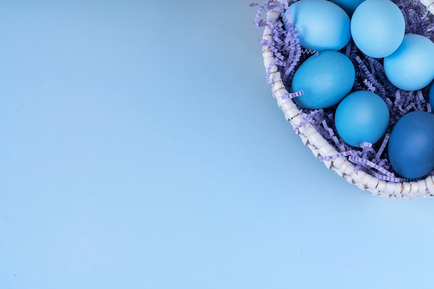 Le uova di Pasqua sono blu e azzurro in un bel cestino.