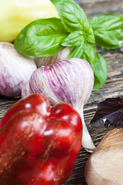 Le verdure non lavate vengono utilizzate per cucinare e mangiare, peperoni rossi e altre verdure mentre si prepara un'insalata o un altro piatto, primo piano