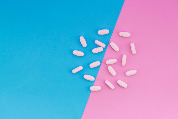 Le vitamine si trovano su uno sfondo colorato. Compresse sullo sfondo pastello blu e rosa. Posto per il testo. Vista dall'alto
