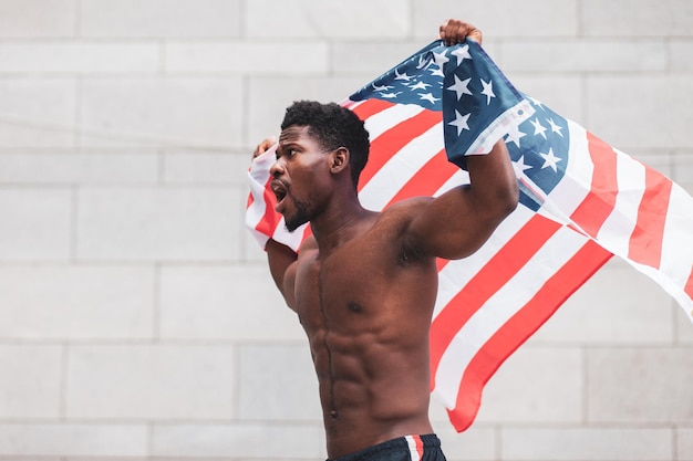 Le vite nere contano il concetto Aggressivo ragazzo afroamericano con proteste e grida di bandiera degli Stati Uniti