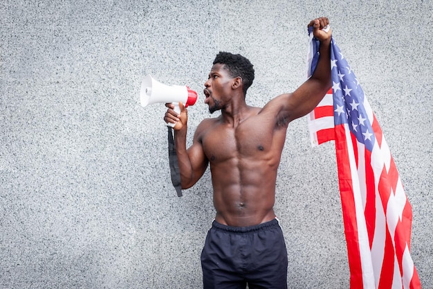 Le vite nere contano il concetto Aggressivo ragazzo afroamericano con proteste e grida di bandiera degli Stati Uniti