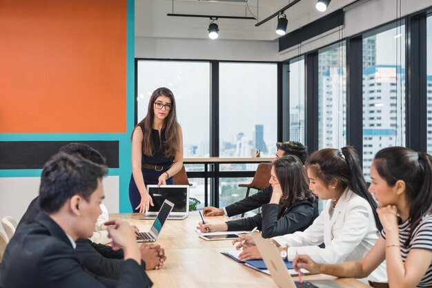 Leader del team caucasico e colleghi di lavoro multietnici che si incontrano seriamente sul futuro piano aziendale dell'ufficio moderno