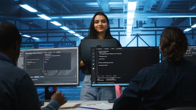 Leader di squadra felice che coordina i dipendenti che controllano i colli di bottiglia del data center