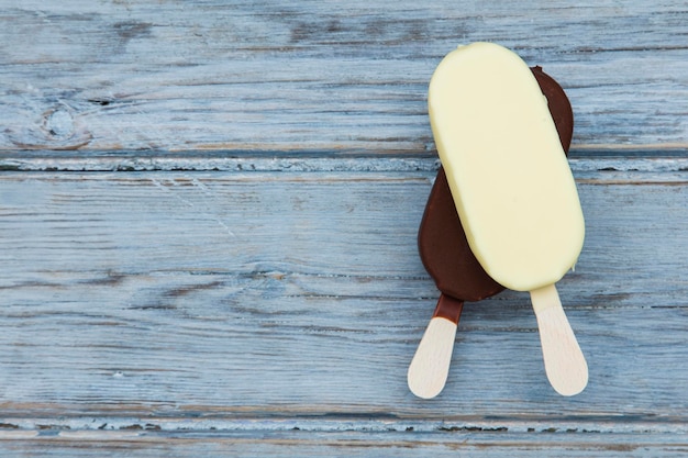 Lecca lecca del gelato al cioccolato su un fondo di legno