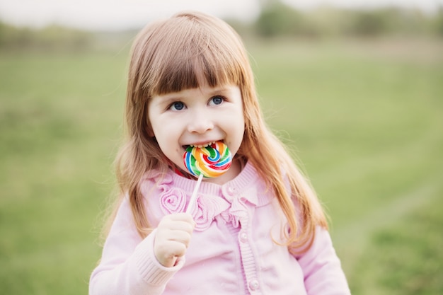 Lecca-lecca della tenuta della bambina in sua mano