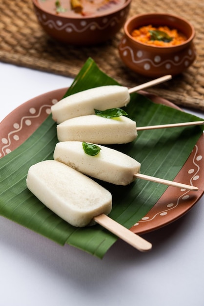 Lecca-lecca pigra o caramelle idli con stick servite con sambar e chutneyColazione indiana del sud