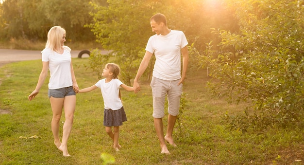 Legami familiari. Felice giovane famiglia di tre persone che sorride mentre trascorre il tempo libero all'aperto