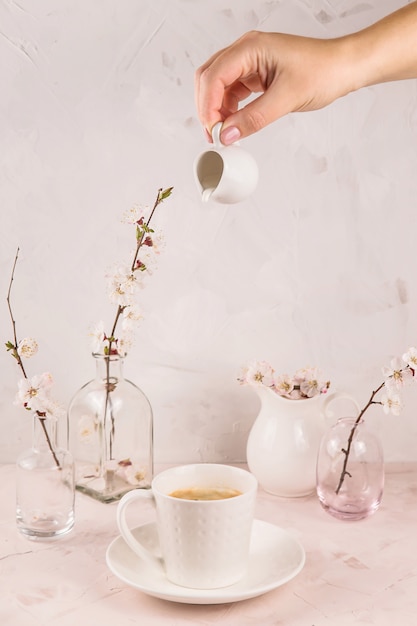 Leggera e minimalista still life con un movimento di crema versando nel caffè