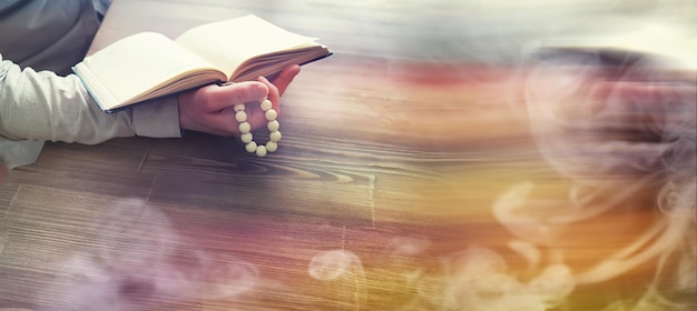 Leggere la letteratura religiosa Un uomo studia il Corano e ordina il rosario