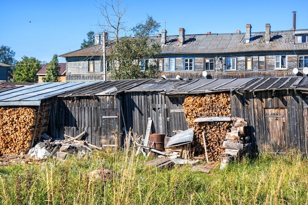 Legna da ardere sotto il tetto di un fienile sulle isole Solovetsky e un edificio residenziale in legno con finestre