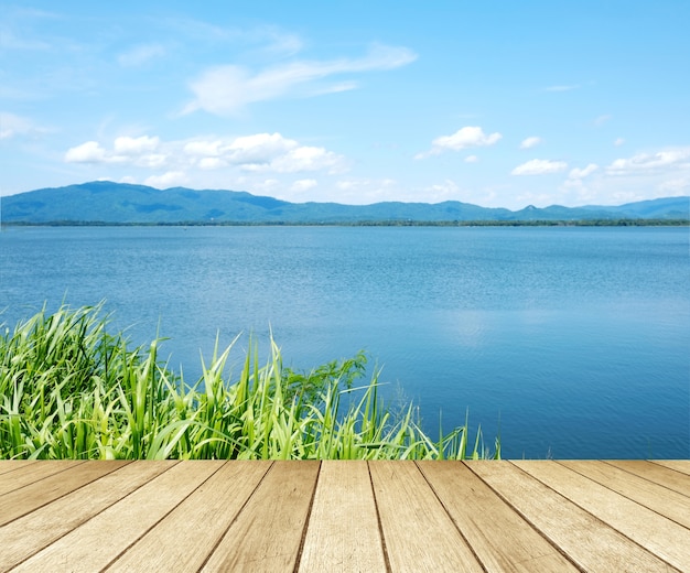 Legno vuoto di prospettiva sopra la priorità bassa del cielo blu e del lago