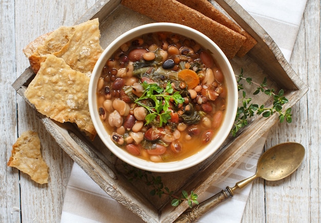 Legumi e verdure cotte in una ciotola sulla vecchia vista del piano d'appoggio di legno